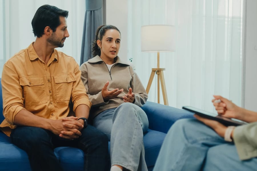 A couple speaking together in a calm therapy office